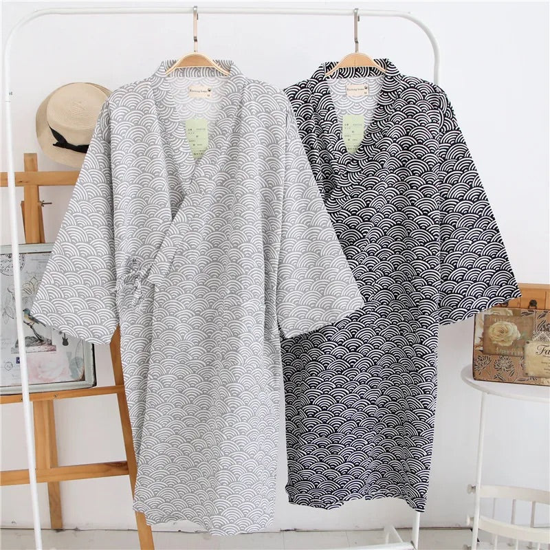 2 robes de chambre kimono pendus à des ceintres de couleur noir et gris avec des motifs de demi cercle blanc, 