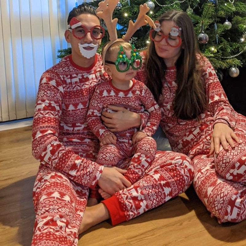 famille devant leur sapin de noel en pyjama de noel assortis