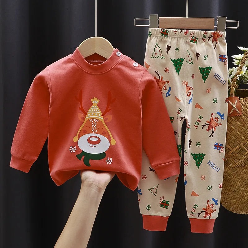 photo d'un pyjama Pyjama Bébé,Enfant Noël avec un haut rouge orangé avec un renne de noël au centre et un pantalon beige avec des motifs divers de noël