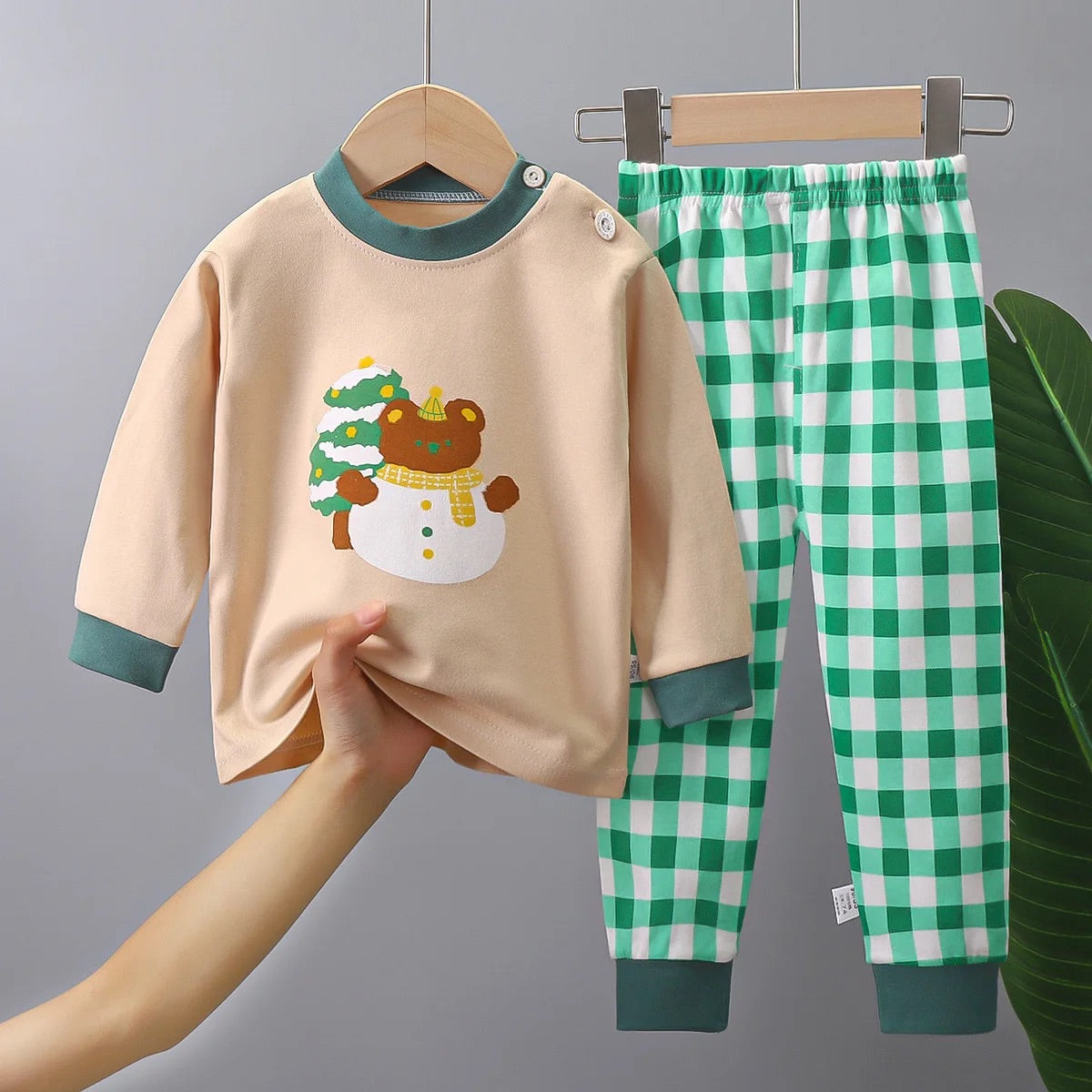 photo d'un pyjama Pyjama Bébé,Enfant Noël, composé  d'un haut beige avec motif d'ourson de noël et un pantalon a carreau vert et blanc 