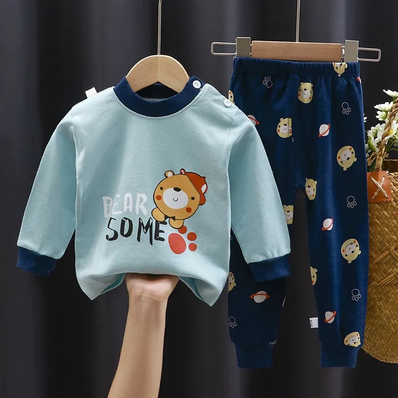 Pyjama Ourson pour Bébé/Enfant composé d'un bleu clair avec au centre un petit ourson brun clair avec une casquette rouge et une écriture "bear some" et un pantalon bleu nuit avec des petites têtes d'ourson et des planètes 