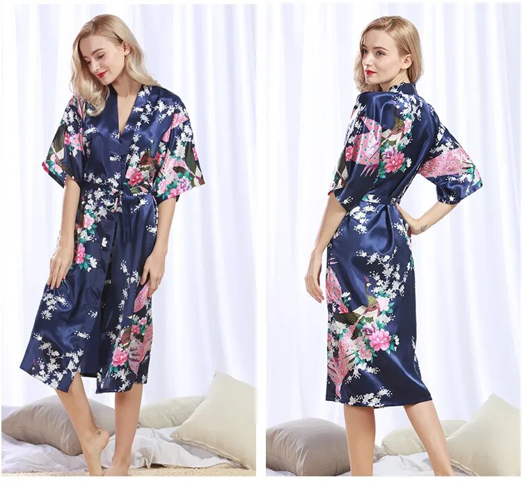 2 photos d'une femme portant un pyjama kimono en satin bleu foncé à motifs floraux et de paon