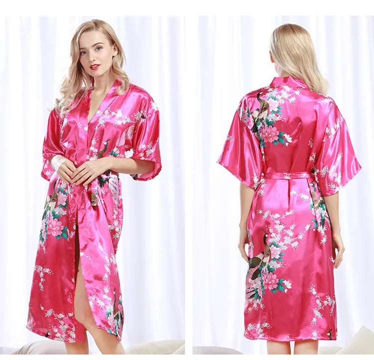 2 photos d'une femme portant un pyjama kimono en satin rose fuchsia à motifs floraux et de paon