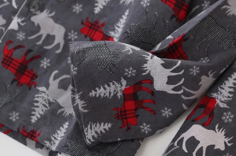 zoom sur la manche d'un  pyjama de noel à motifs de rennes, flocons et sapins 