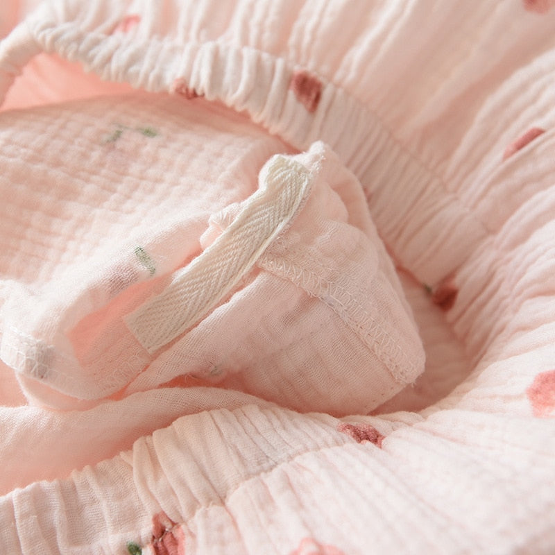 pyjama rose avec zoom sur coutures avec motif pêche sur fond blanc